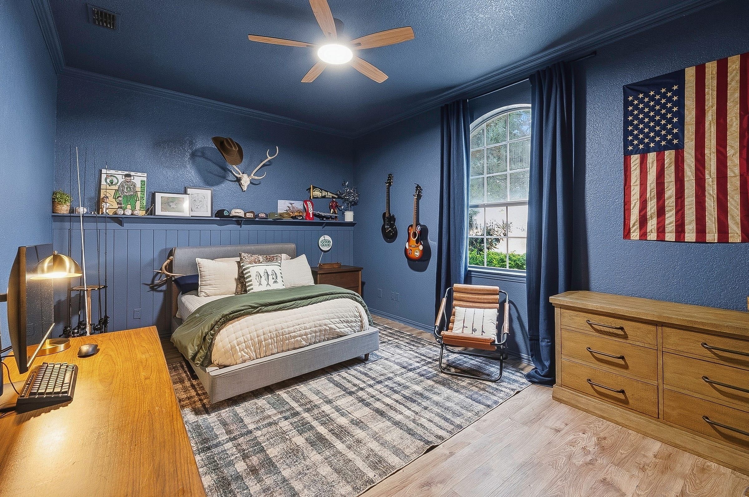 Bedroom with blue walls and wood flooring
