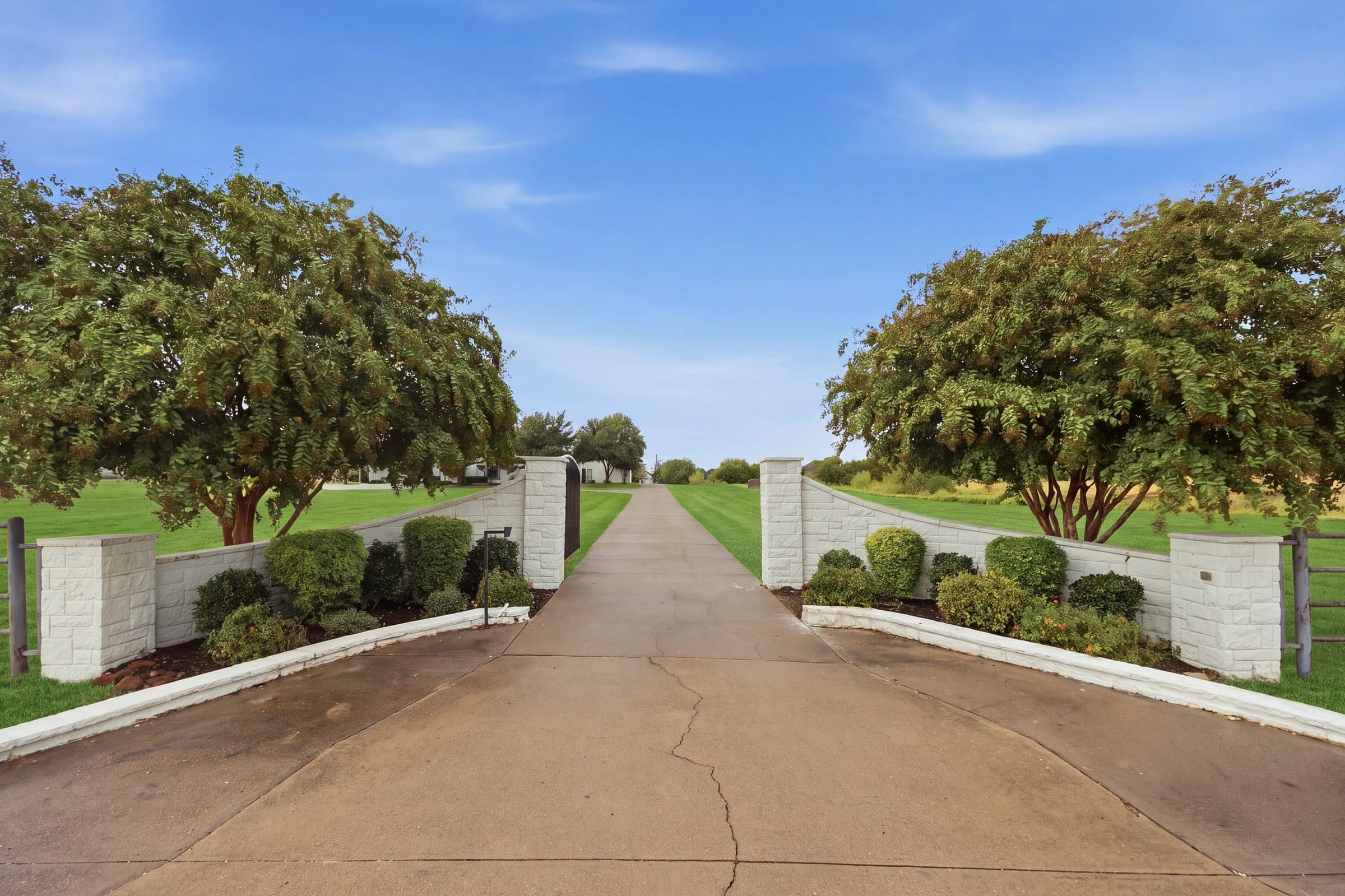 Stone entry columns and the long concrete driveway