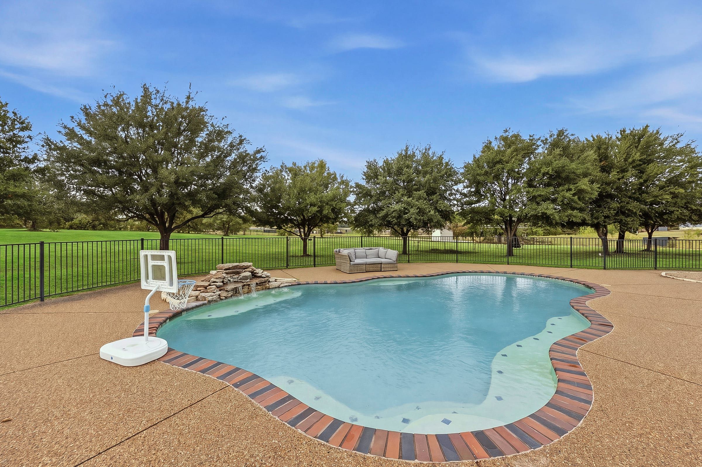 In-ground pool with rock waterfall