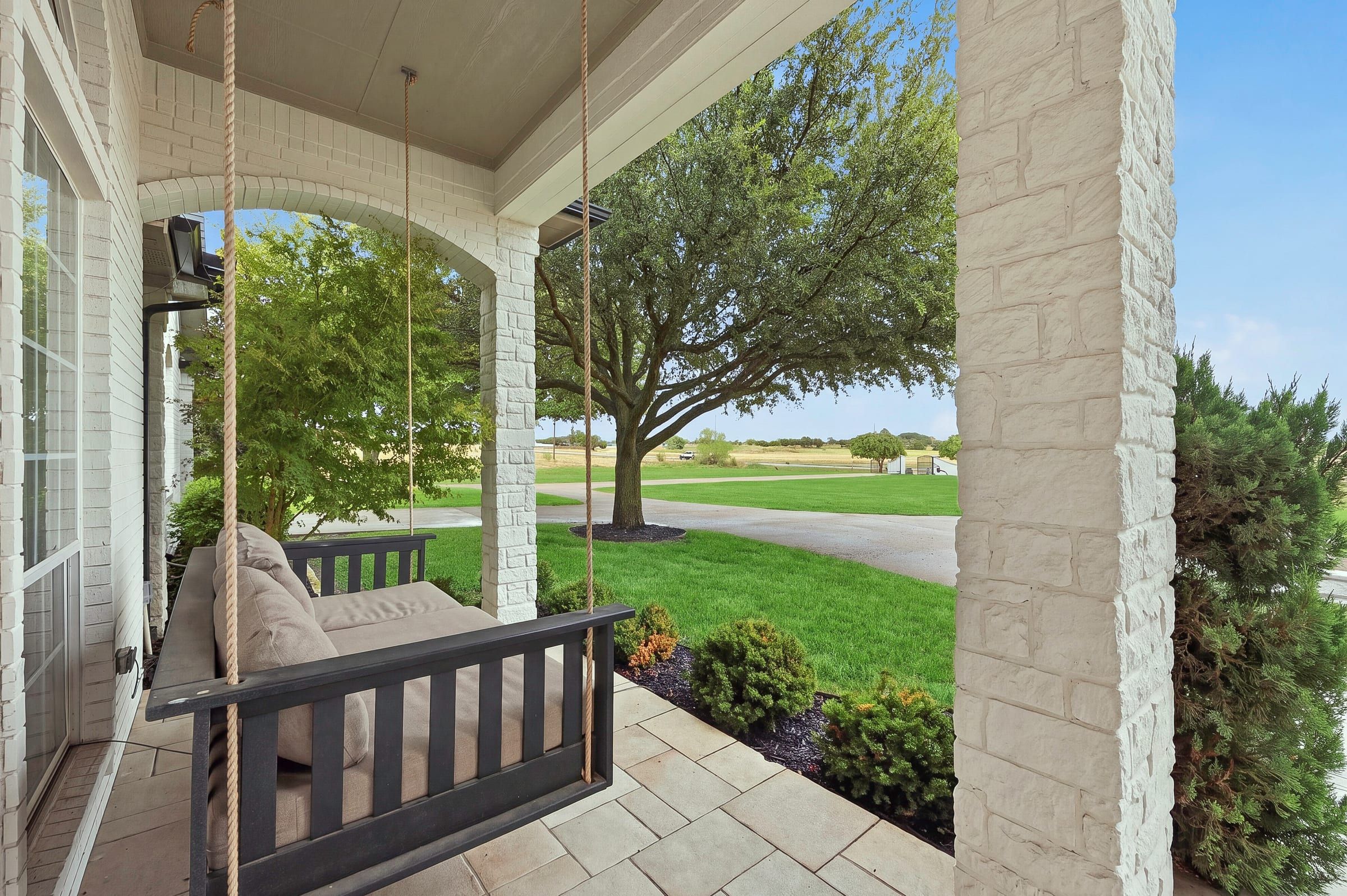 Daybed swing on the covered front porch looking out over the front lawn