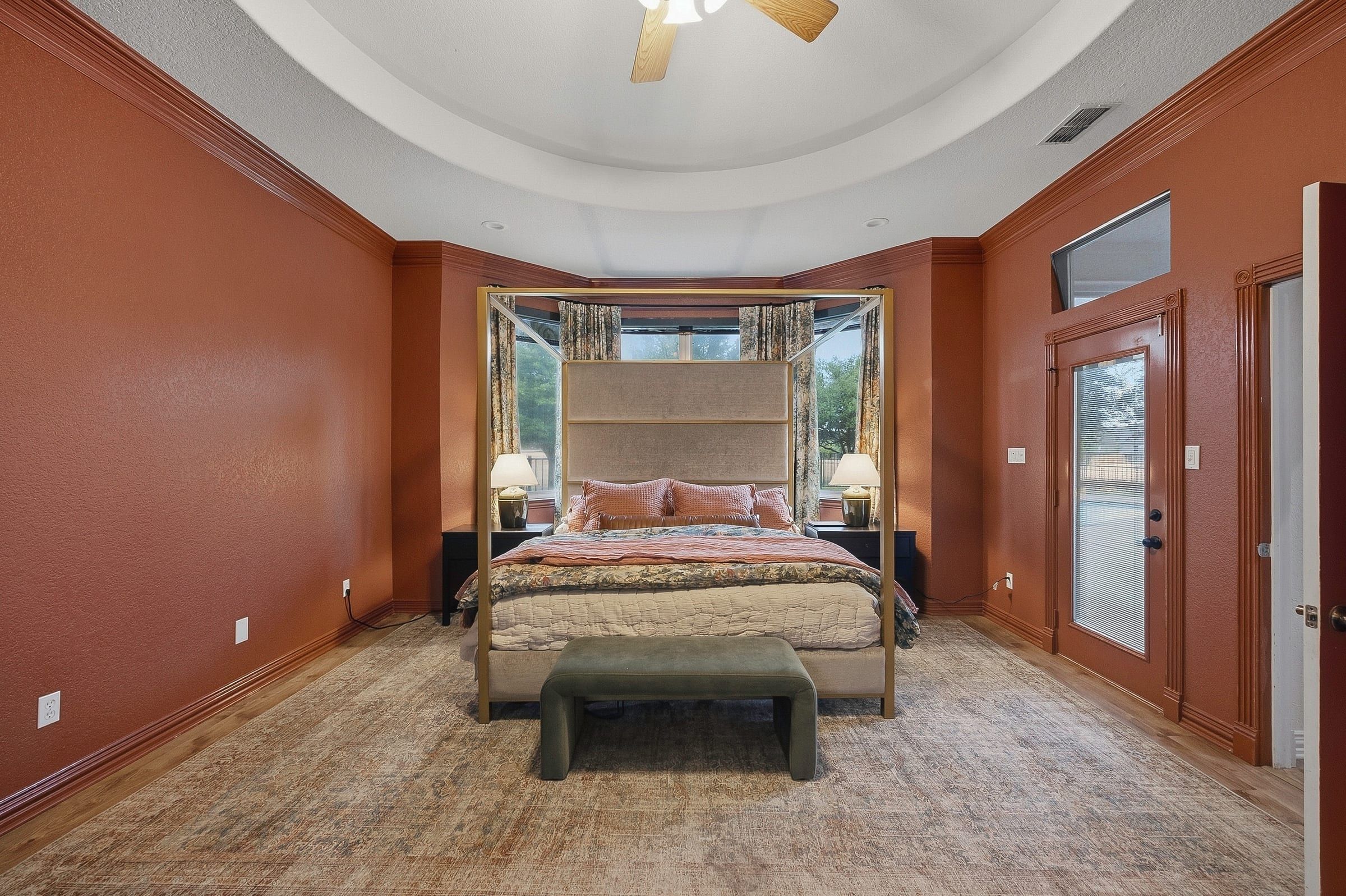 Primary bedroom with tray ceiling and door to the patio
